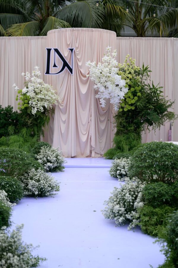 Trang trí cưới sân vườn với backdrop lụa mềm mại và hoa tươi tinh tế, tạo không gian decor đám cưới ngoài trời sang trọng.