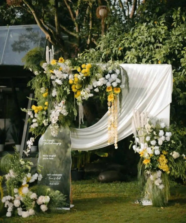 Decor cưới ngoài trời với backdrop vải mềm mại kết hợp hoa tươi nghệ thuật, tạo không gian wedding outdoor sang trọng và lãng mạn.