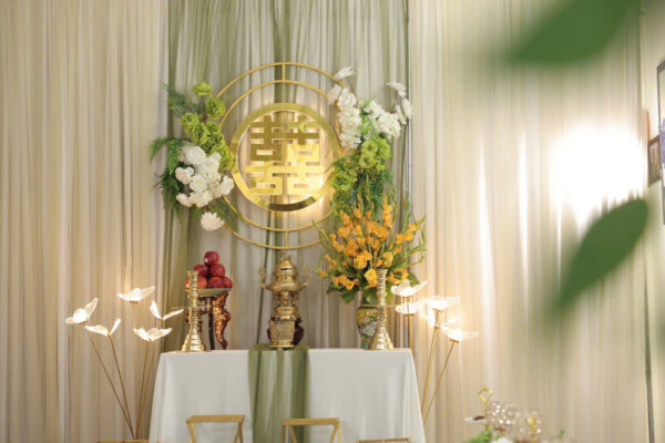 Bàn thờ gia tiên tone vàng gold hiện đại kết hợp chân nến và hoa tươi sang trọng tại TP.HCM